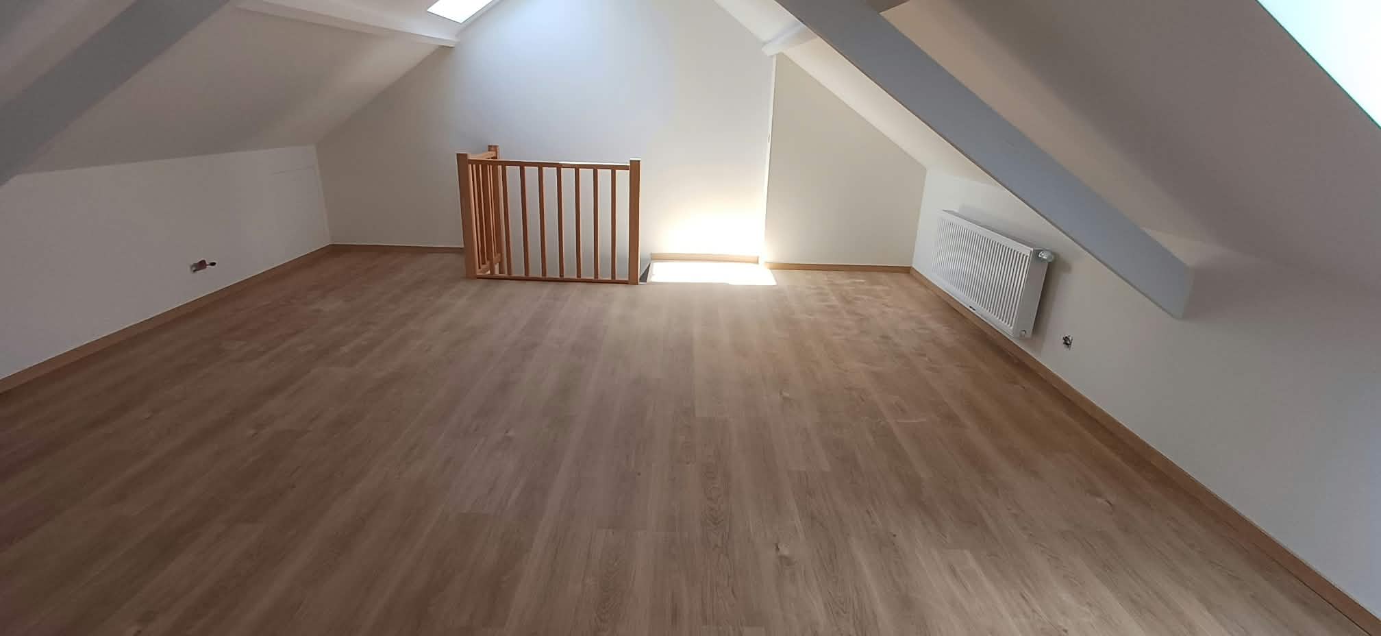 Vue générale de la pièce sous combles avec plancher et garde-corps en bois